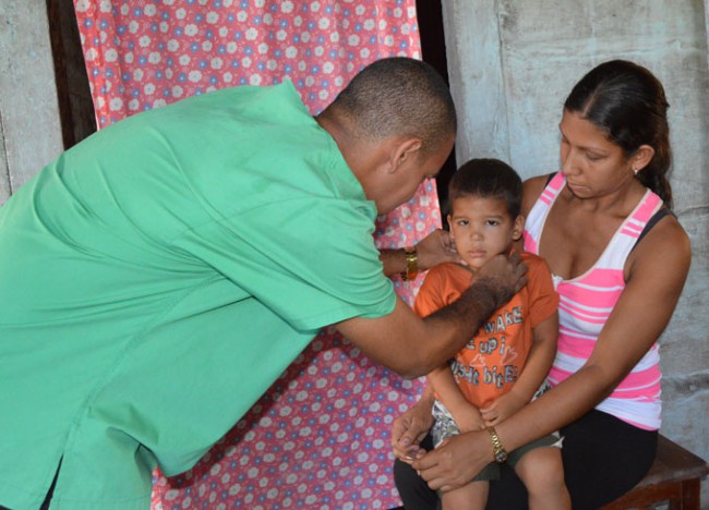 El médico Adrián Alcolea atiende al niño Yurisnel Verdecia, en su casa./Foto: Lino Valerino.