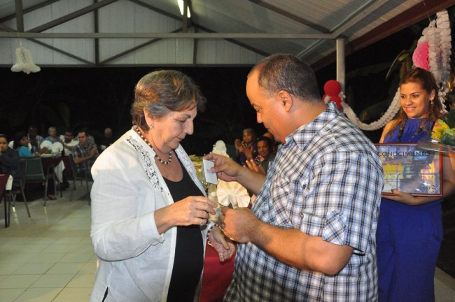 Federico Hernández, primer secretario del PCC en Granma, condecora a Gloria Guerrero. Foto/Rafael Martínez Arias