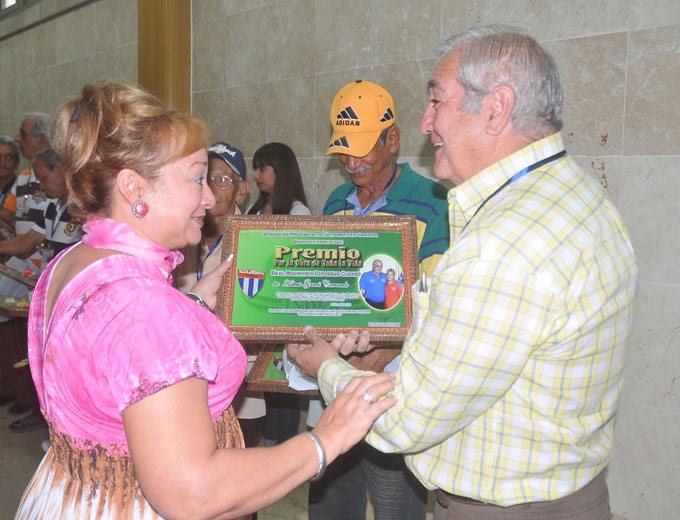 Garcés Carracedo recibe el reconocimiento de Carmen González Álvarez, miembro del Buró provincial del PCC / Foto Luis Carlos Palacios Leyva