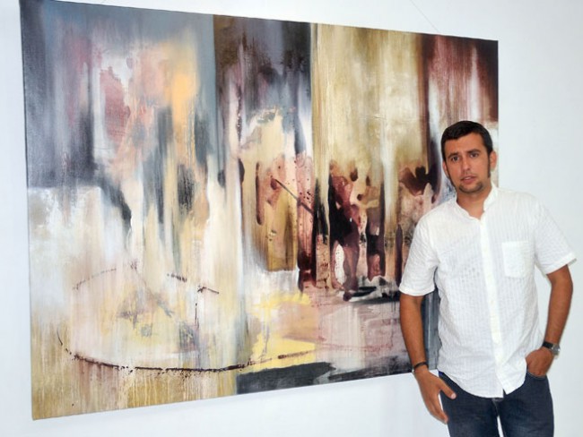 El pintor Raylven Friman junto a una de sus obras. Foto Luis Carlos Palacios