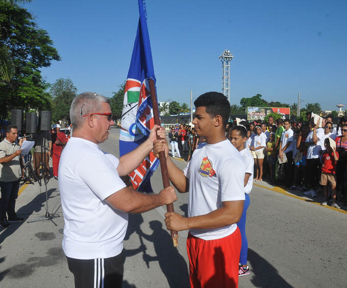 El Director provincial de Deportes Oscar Arturo Nuevo Reyes entrega el estandarte al pesista bayamés Erik Millares Blanco, monarca de la edición anterior / Foto Luis Carlos Palacios Leyva
