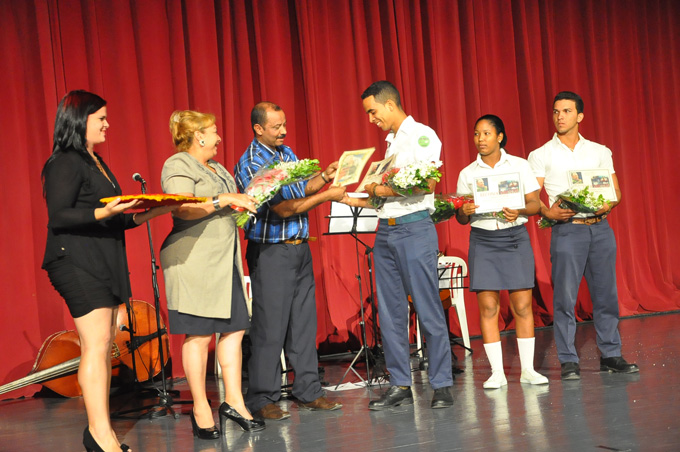 Leonardo Tamayo Vázquez, director de Educación en Granma, felicita a Ernesto Michel Mompié Tornés, estudiante integral de la graduación. Junto a él, Isabela Vázquez y Reidisnel Rosales, estudiantes destacadosFOTO/Rafael Martínez Arias