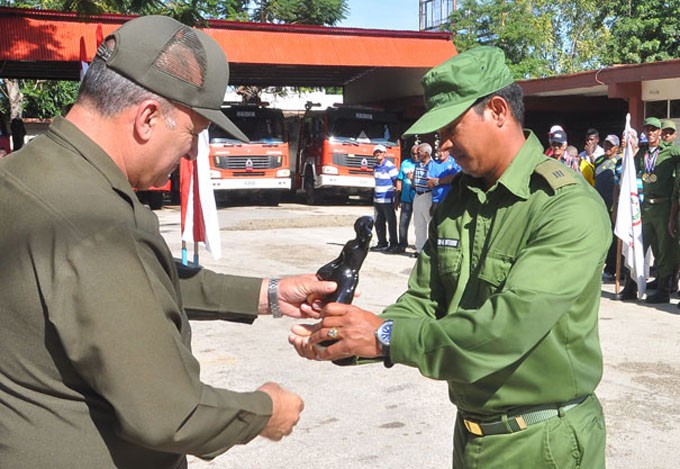 El entrenador del equipo de bomberos de Granma recibe del Coronel Wilson Ortiz Méndez la medalla aniversario 320 FOTO/Rafael Martínez Arias