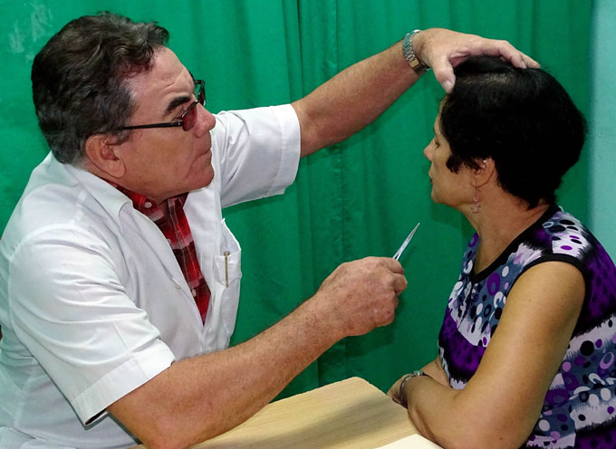 Tony aplica a María López tratamiento para sus dolores óseos. Foto: Luis Carlos Palacios Leyva.